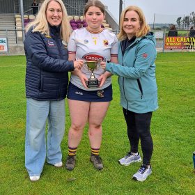 12th Oct Well done to our fabulous Minor girls who defeated Four Roads today in the replay of the Minor B Championship held in Lisnamult this afternoon. A great start with early goals set the foundation for this win and we were comfortably ahead at half time.Four Roads came storming back into the game in the second half but our girls stood firm especially in defence and some key scores by our forwards towards the end ensured a solid victory and it was a delighted Captain Molly Tully who received the Cup from County Camogie Board Childrens Officer and Executive member Rachel O'Donnell.The Minor Competition was sponsored by our coach Joan Moore Therapy Rooms and Joan was on hand for presentation also. Huge credit goes to the Minor and U16 players and Mgt led by Sean Mulry and Fiona Ni Chuinn who combined to ensure we were able to play and succeed in this competition. Thanks also to our Club Facilities Team for presenting our grounds so well ,to our supporters and to everyone who helped out on the day.